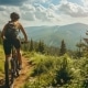 Mountainbikerin fährt im Sommer durch eine Bergwaldlandschaft.