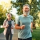 Fröhliches Ehepaar, das gemeinsam an Wettkämpfen teilnimmt und an der frischen Luft joggt. Aktive Menschen in Sportkleidung beim Cardio-Training.