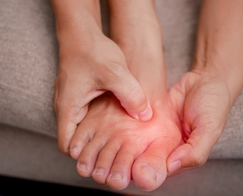 Nahaufnahme eines Fußes. Durch einen roten Verlauf wird ein geschwollener Zeh signalisiert