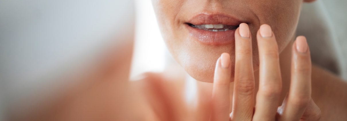 Frau, die ihre Lippen berührt